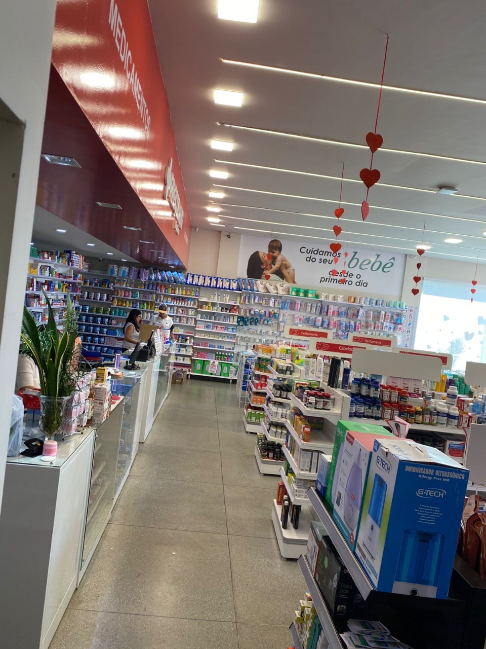 Ambiente interno da Farmácia Preço Baixo com setores de bebê e medicamentos